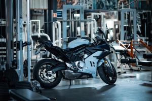 A sleek motorcycle parked indoors among gym equipment, capturing an unusual setting.