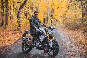 Young man on a motorcycle enjoying a scenic autumn ride in Vilnius, Lithuania.