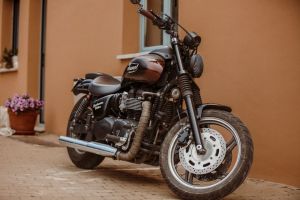 A stylish Triumph motorcycle parked in front of a building in an urban environment.