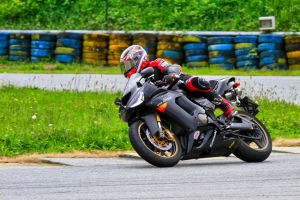 Főoldal 15 Motorcyclist taking a sharp turn on a racing circuit with vibrant background.